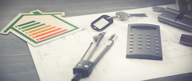 Étiquette énergie, clés et calculatrice posées sur un plan de maison
