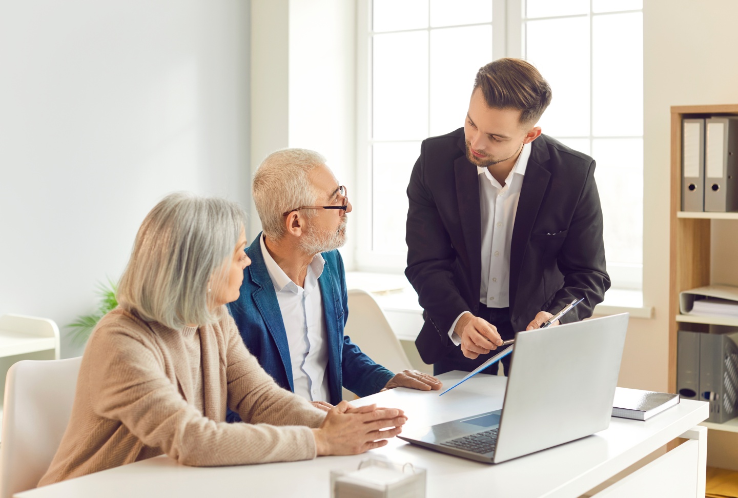 Conseiller immobilier présentant un dossier à un couple de clients