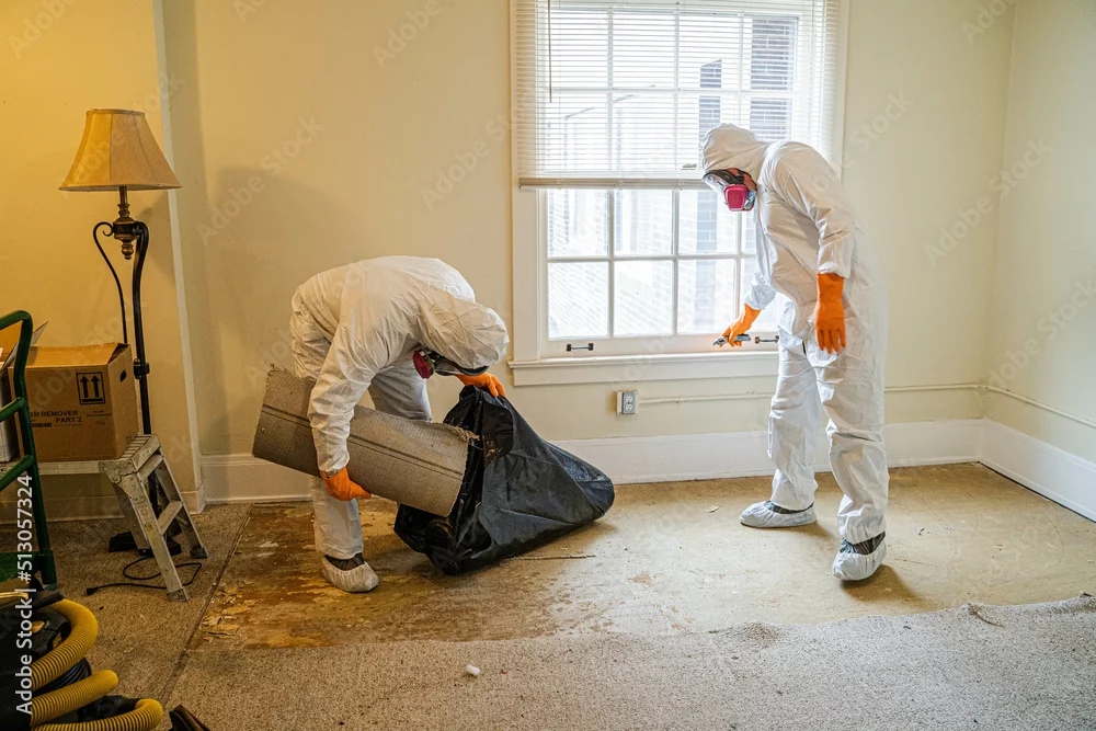 Techniciens en combinaison de protection lors d'un retrait d'amiante