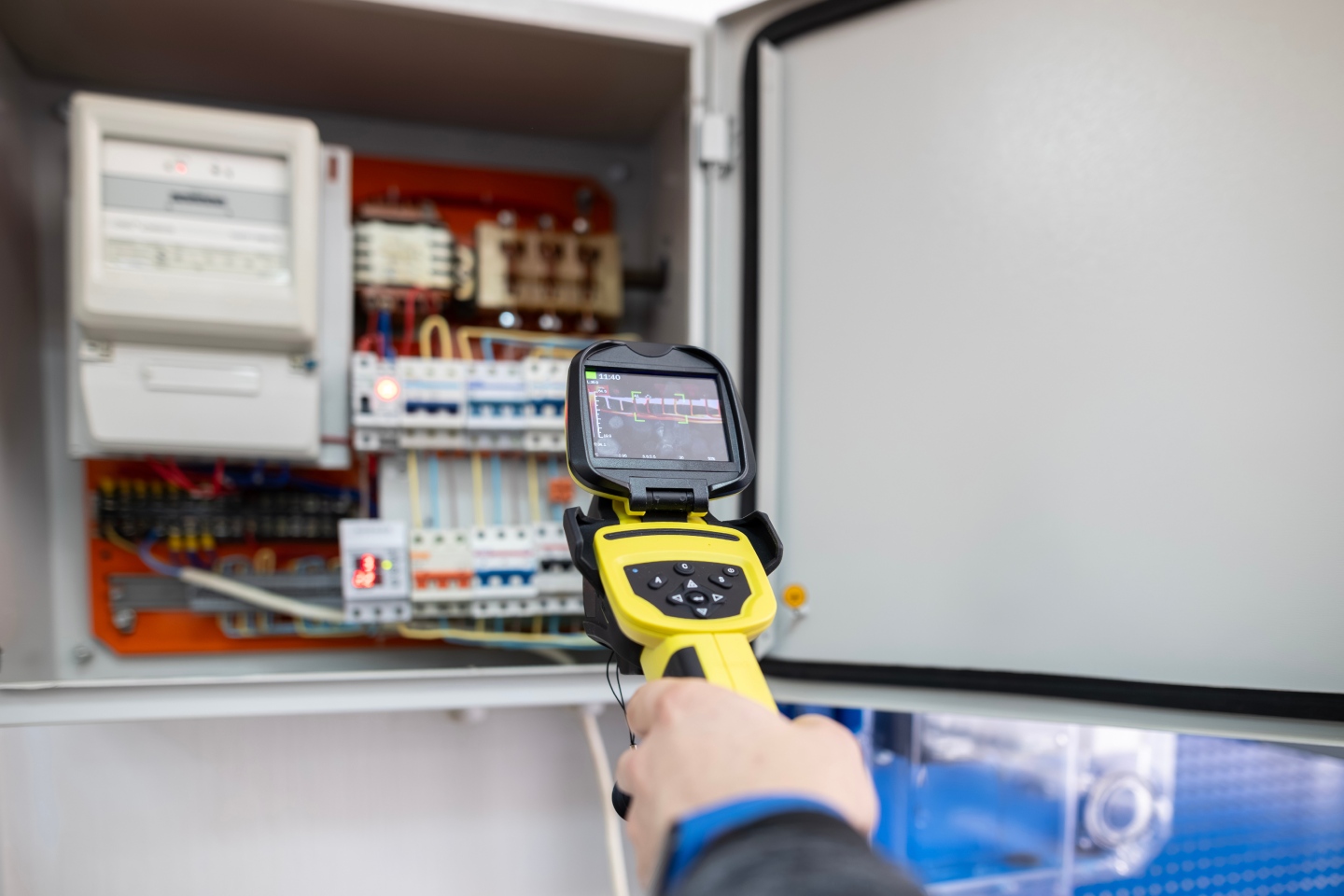 Caméra thermique pointée vers un tableau électrique ouvert